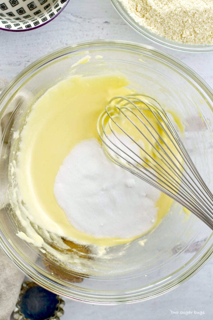 superfine sugar being added to egg yolks