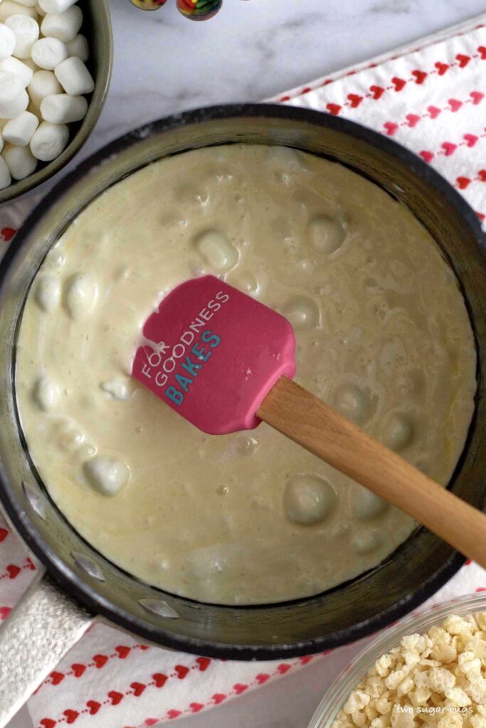 mostly melted marshmallows in a saucepan with a spatula