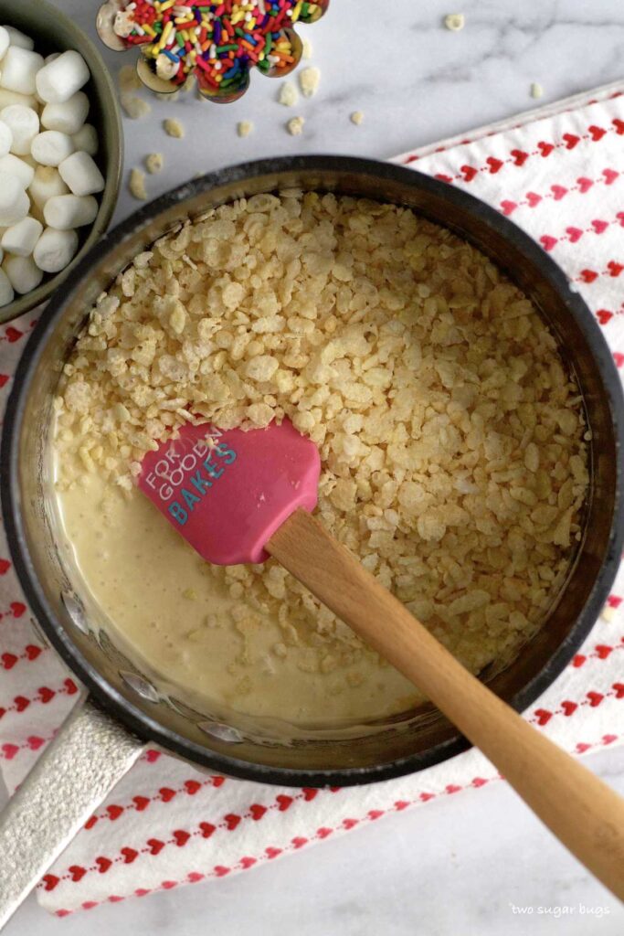 crispy rice cereal added to melted marshmallows in a saucepan