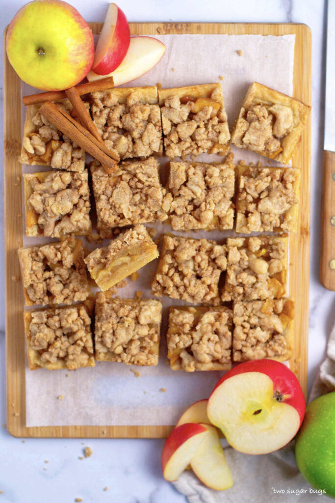 overhead look at cut apple crisp shortbread bars on a parchment lined cutting board