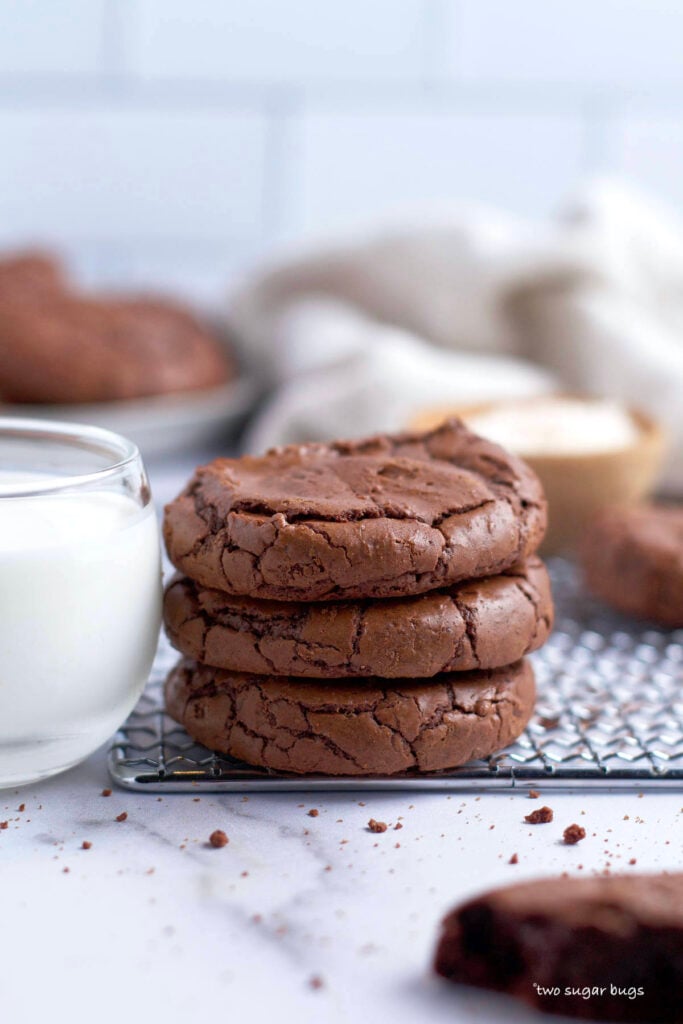 stack of three cookies with a glass of milk
