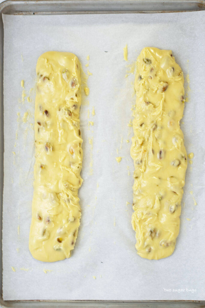 unbaked lemon pistachio biscotti batter on a parchment lined baking sheet