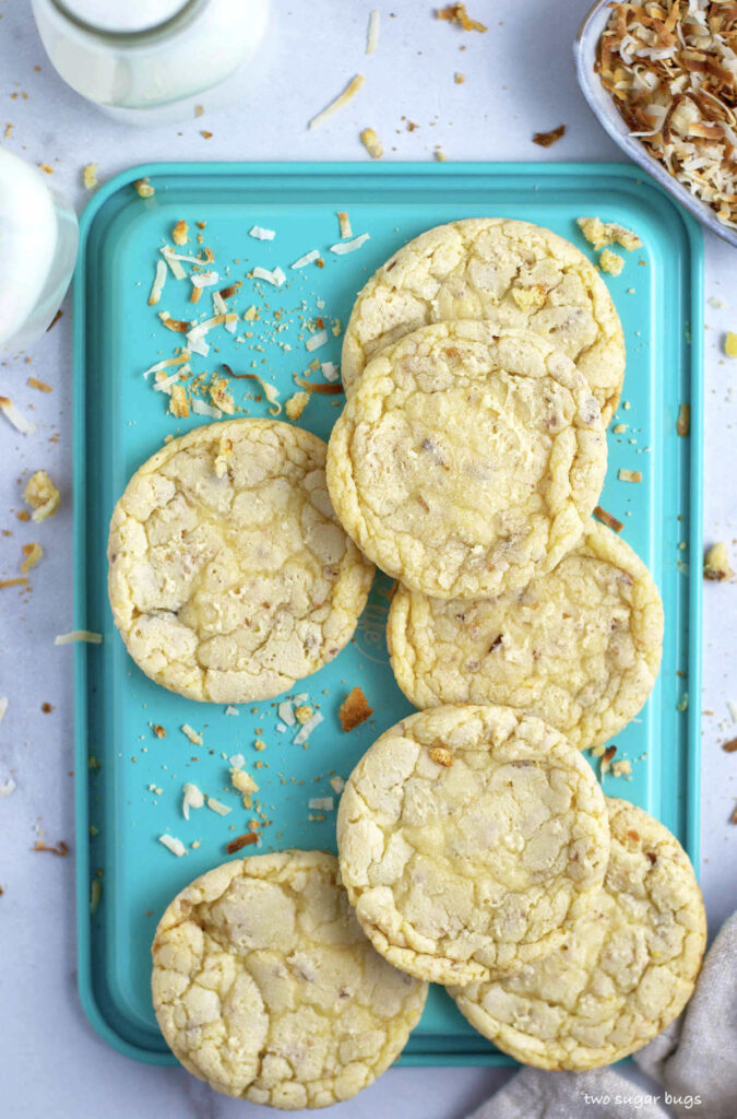 white chocolate coconut cookies on a baking sheet with milk