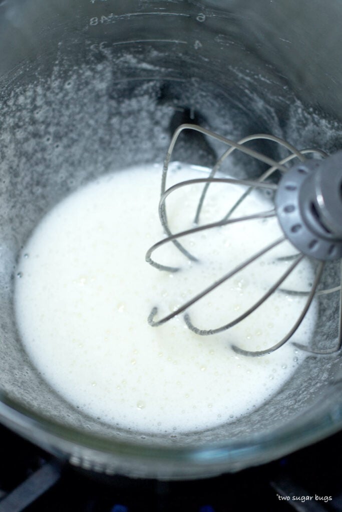 egg whites and sugar becoming frothy in a double boiler
