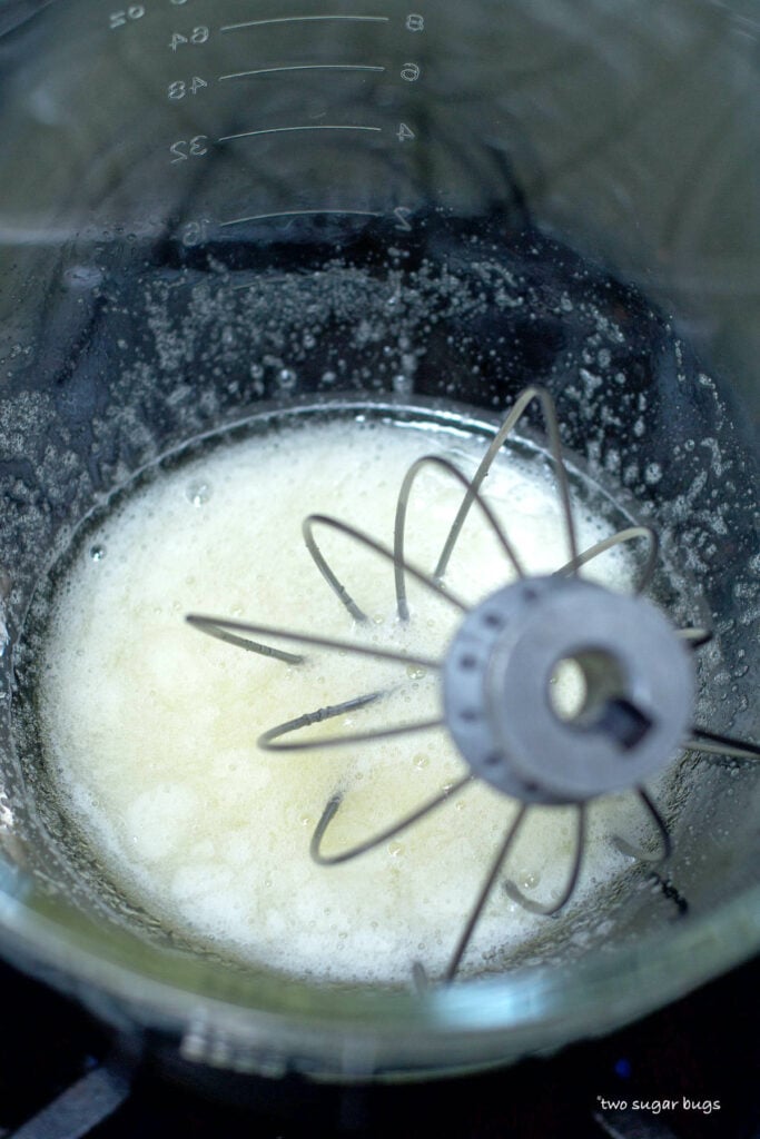 egg whites and sugar being heated over a double boiler