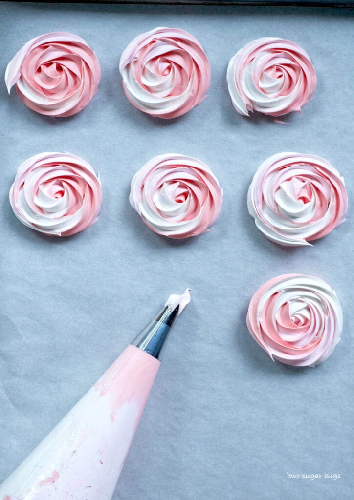 meringue rosettes piped on parchment paper