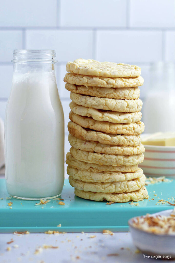 tall stack of cookies next to a glass of milk