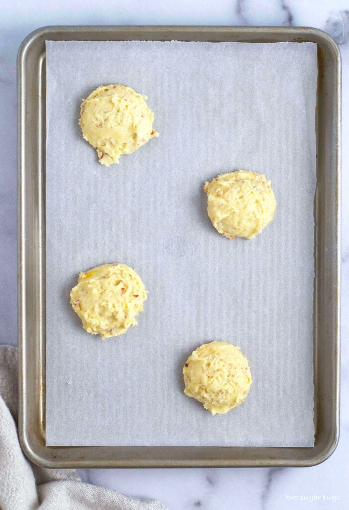white chocolate coconut cookie dough on parchment lined baking sheet