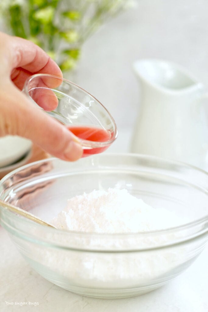 blood orange juice being poured into confectioners' sugar