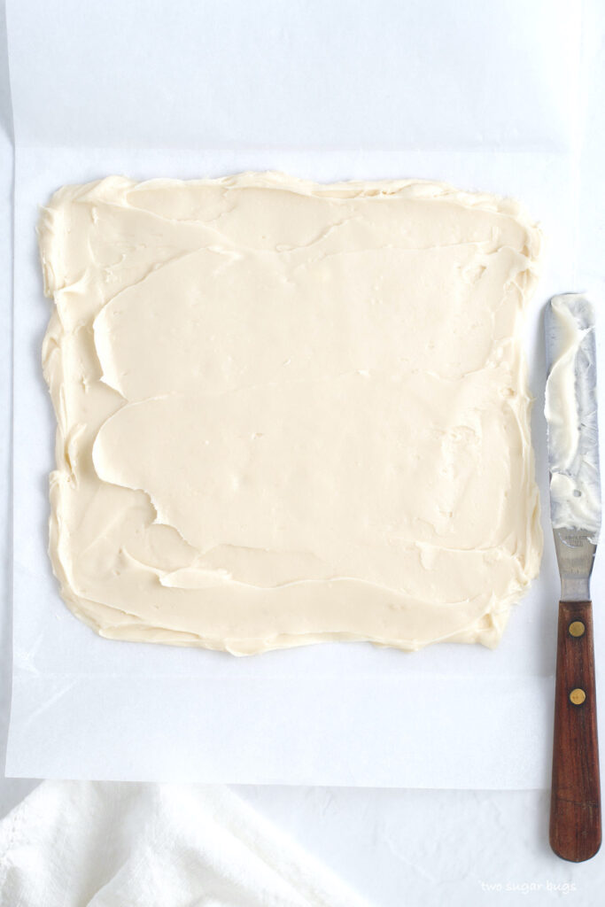 cream cheese frosting filling spread on a piece of parchment paper