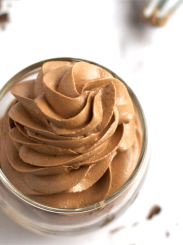 swirled chocolate swiss meringue buttercream in a glass cup