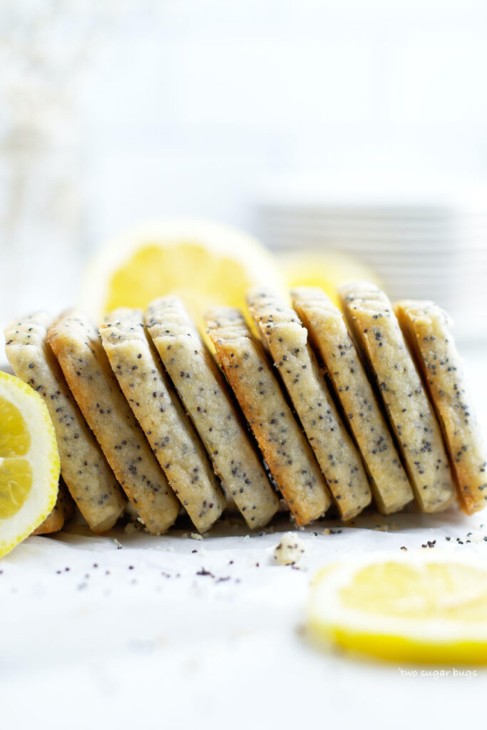 lemon poppy seed cookies laying on their side with lemons