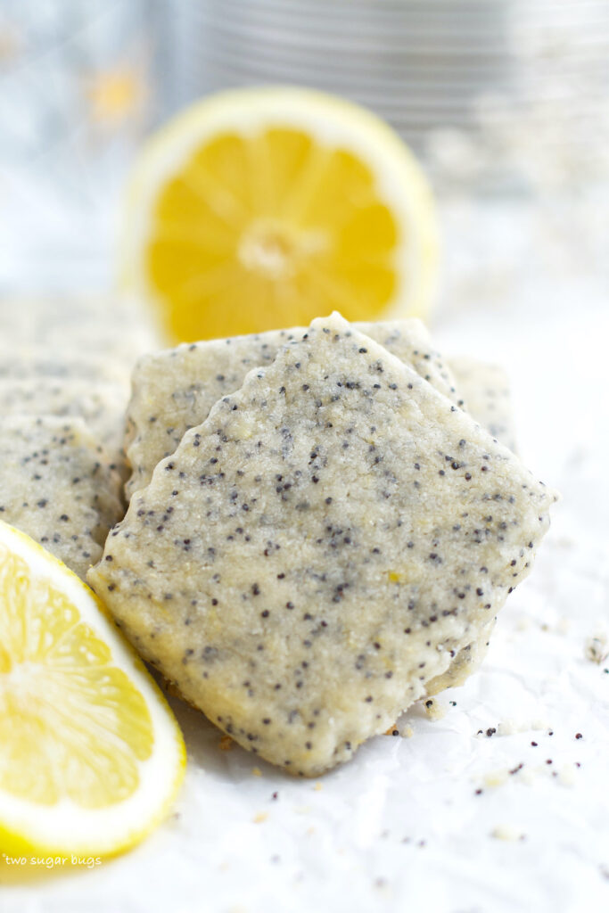 lemon poppy seed cookie with lemon and plates in the background