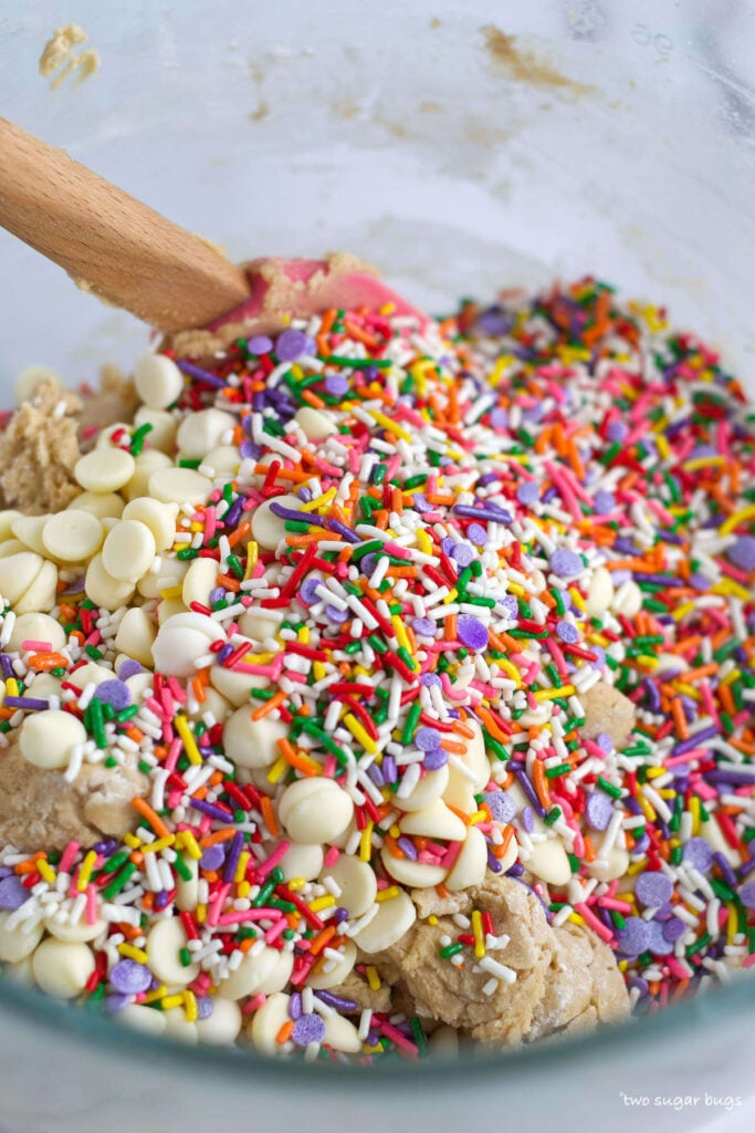 sprinkles and white chocolate chips on top of cookie dough