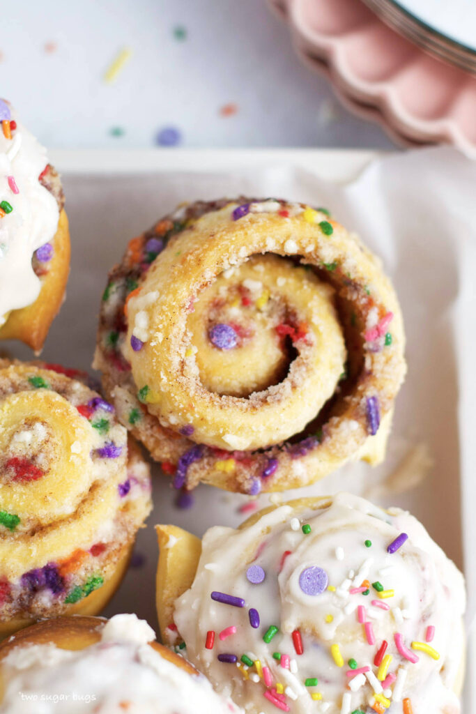 overhead look at funfetti cinnamon rolls with glaze and without glaze