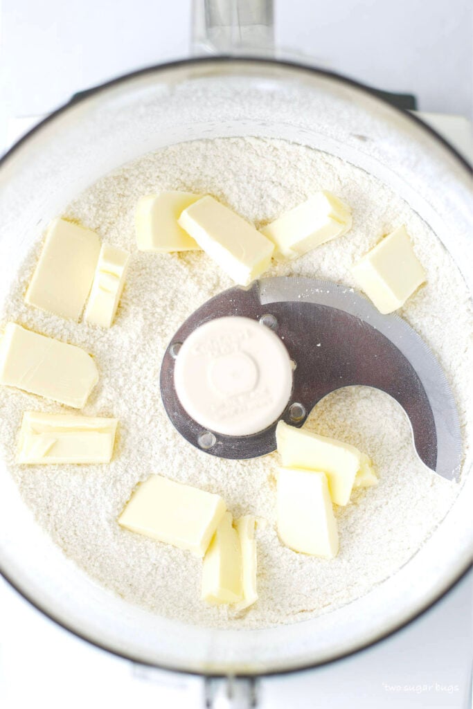 cubed butter on top of dry cake mix ingredients in a food processor