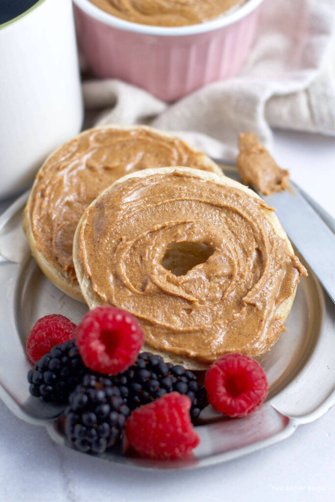 a bagel topped with homemade gluten free cookie butter on a plate with berries