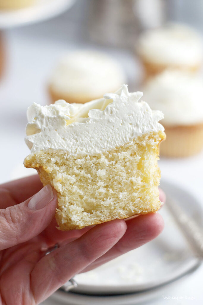 hand holding a white chocolate cupcake showing inside texture