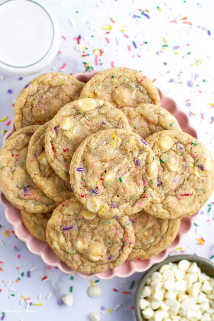 a plate of birthday cake cookies with milk