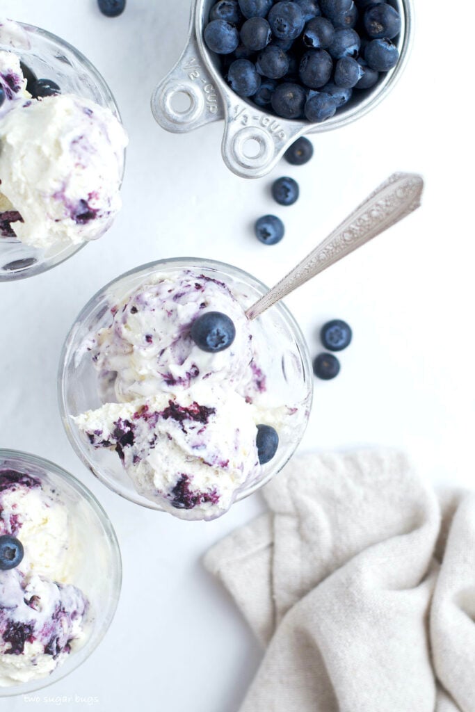 three bowls of white chocolate ice cream with roasted blueberries