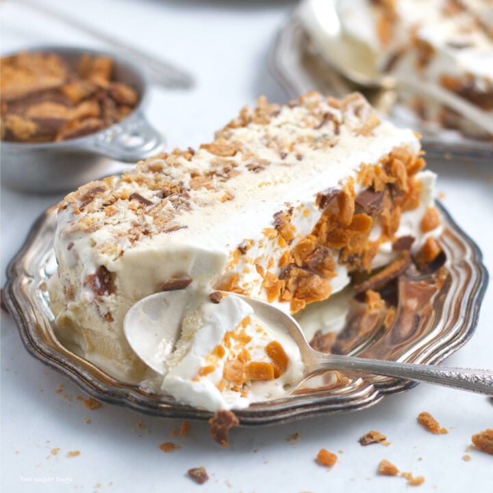 slice of butterfinger ice cream cake on a plate with a spoon