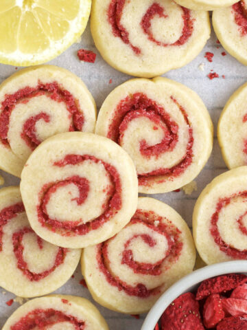 lemon sugar cookies with strawberry swirl with a bowl of dried strawberries