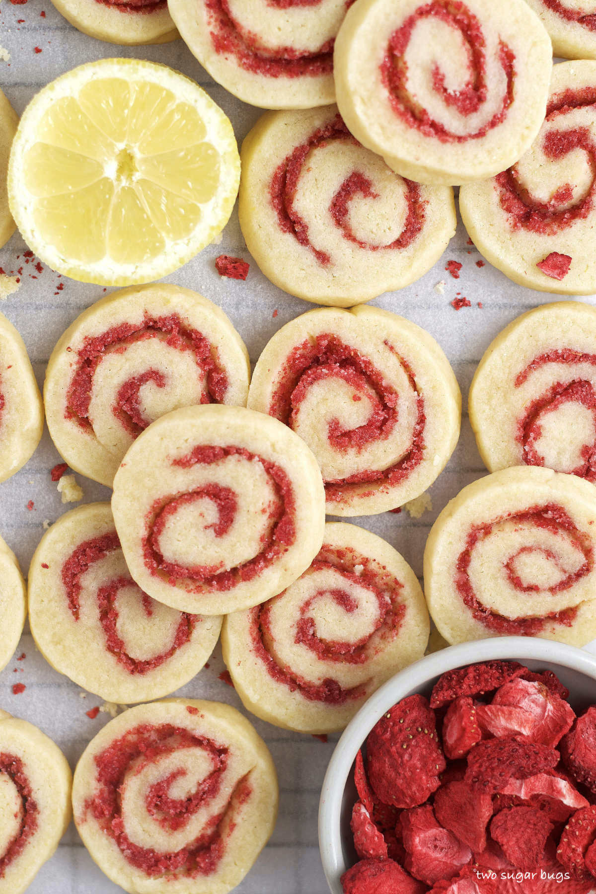 lemon sugar cookies with strawberry swirl with a bowl of dried strawberries