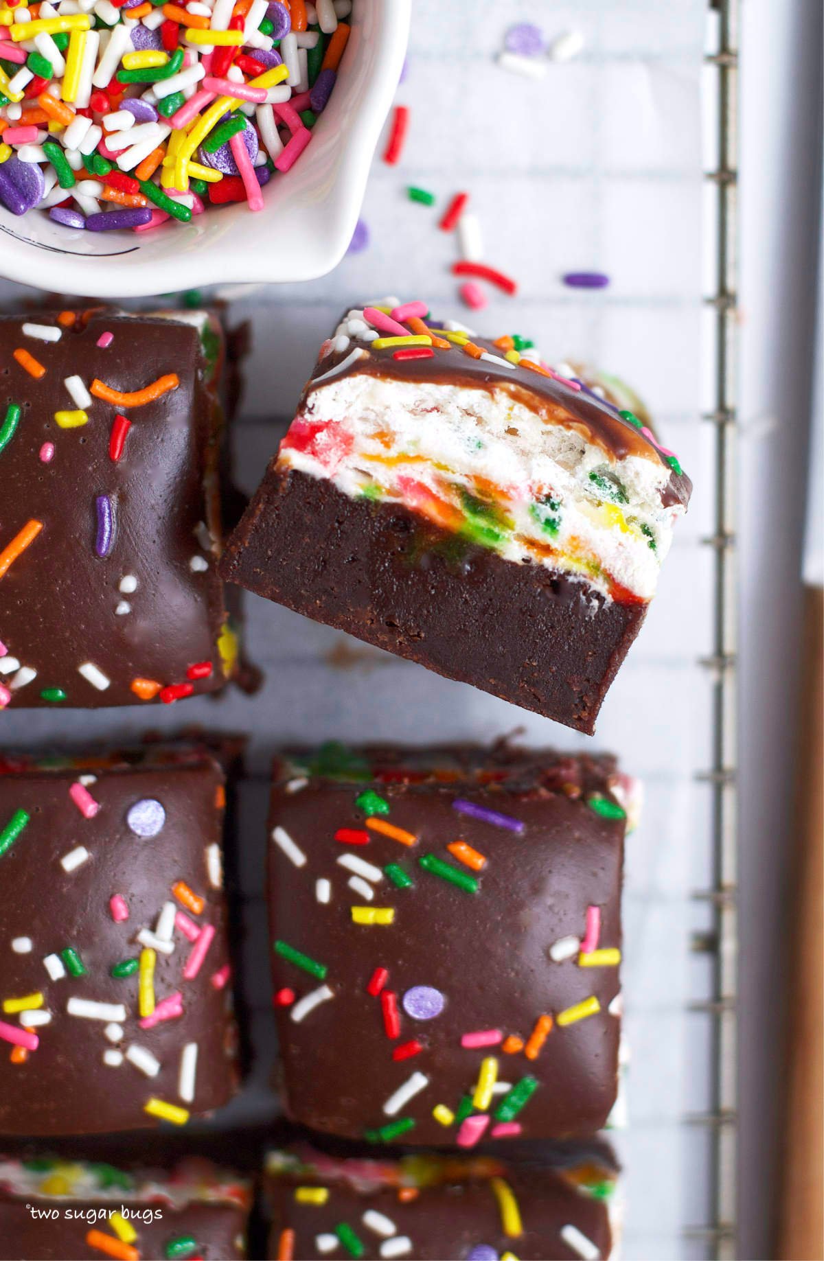 three layer funfetti brownies with a bowl of sprinkles