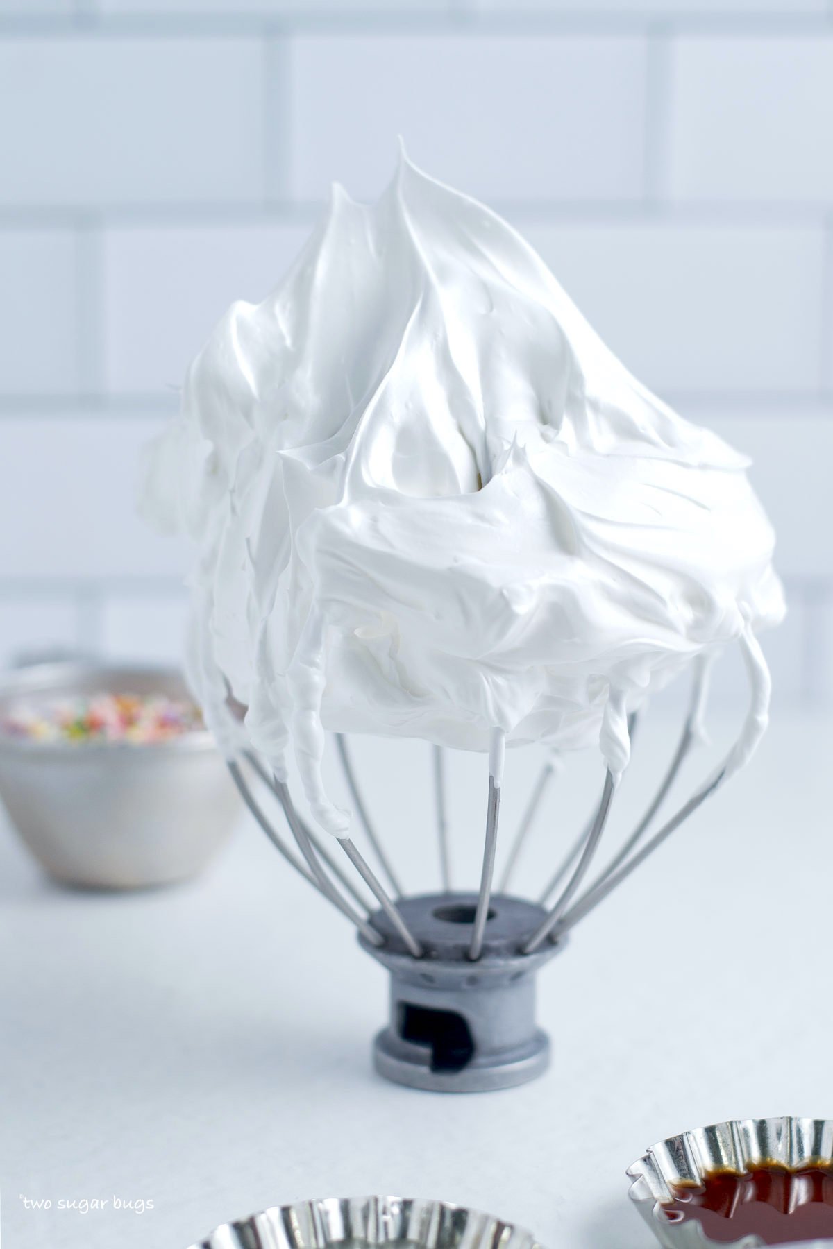 whisk showing stiff peaks of meringue