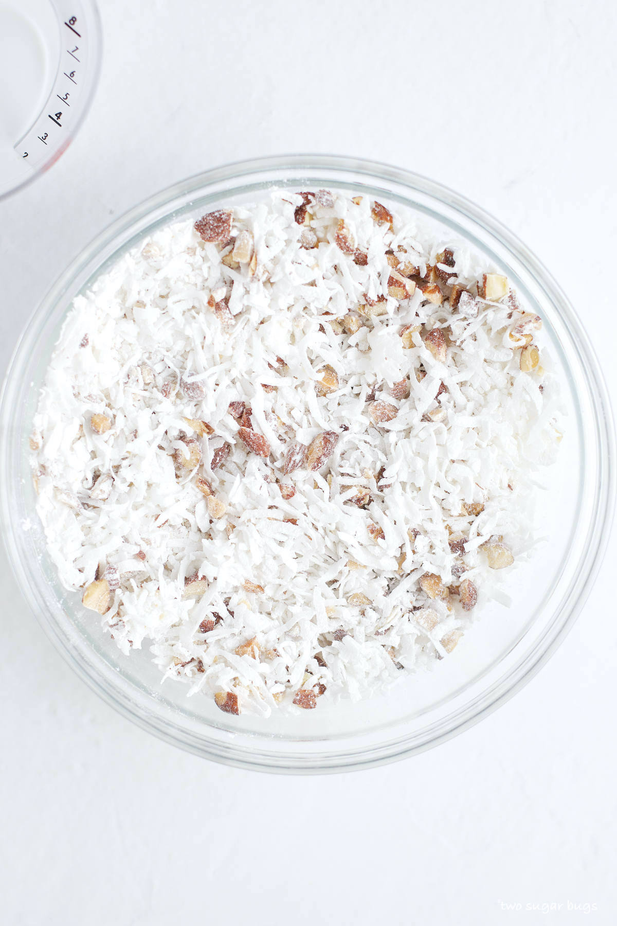 shredded coconut, almonds and confectioners' sugar mixed in a bowl