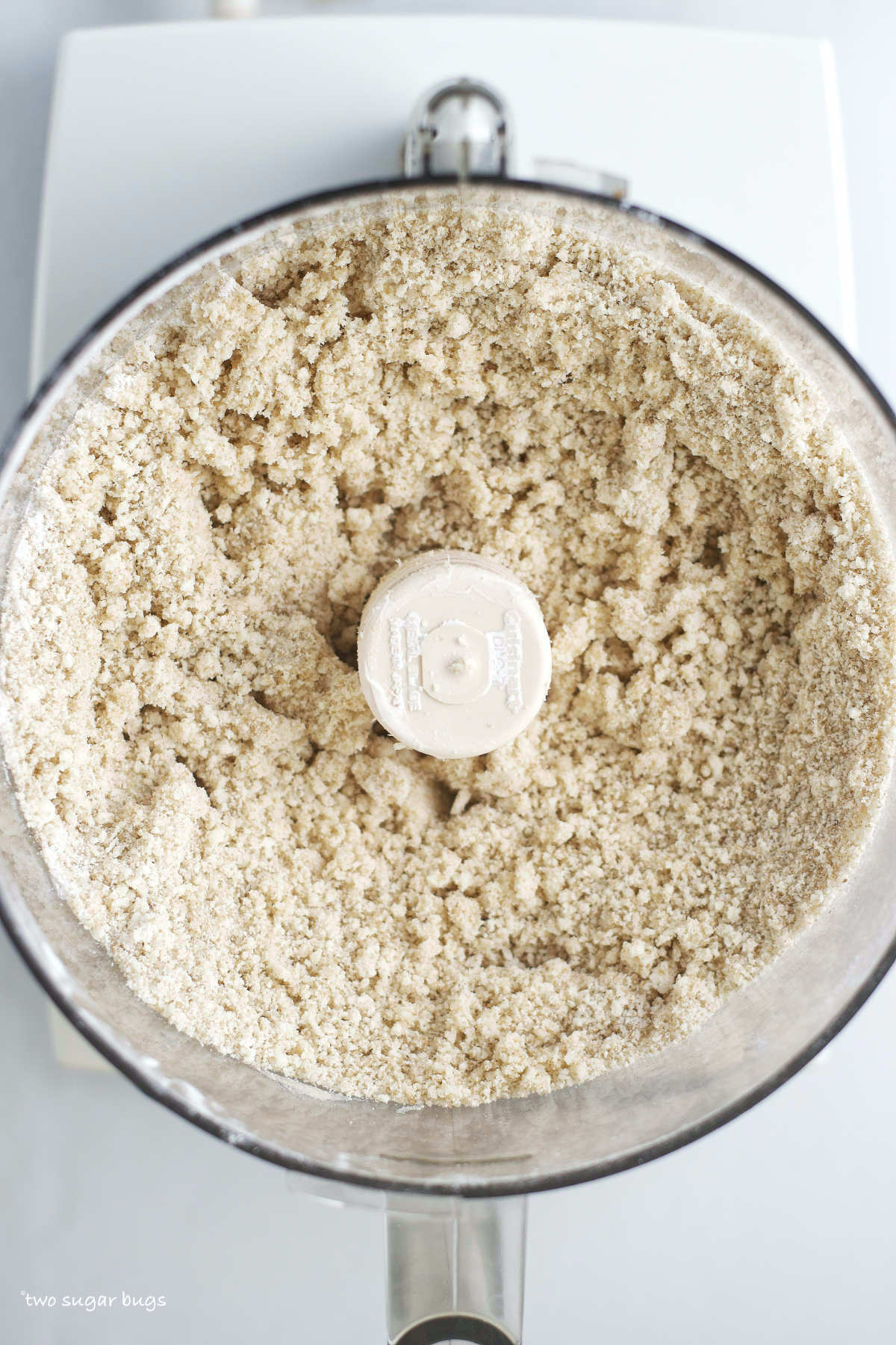 cookie ingredients resembling sand in a food processor