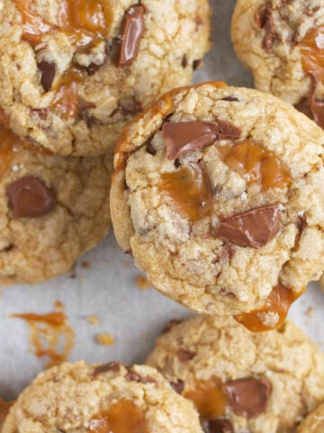 caramel chocolate chip cookies with sea salt on parchment paper