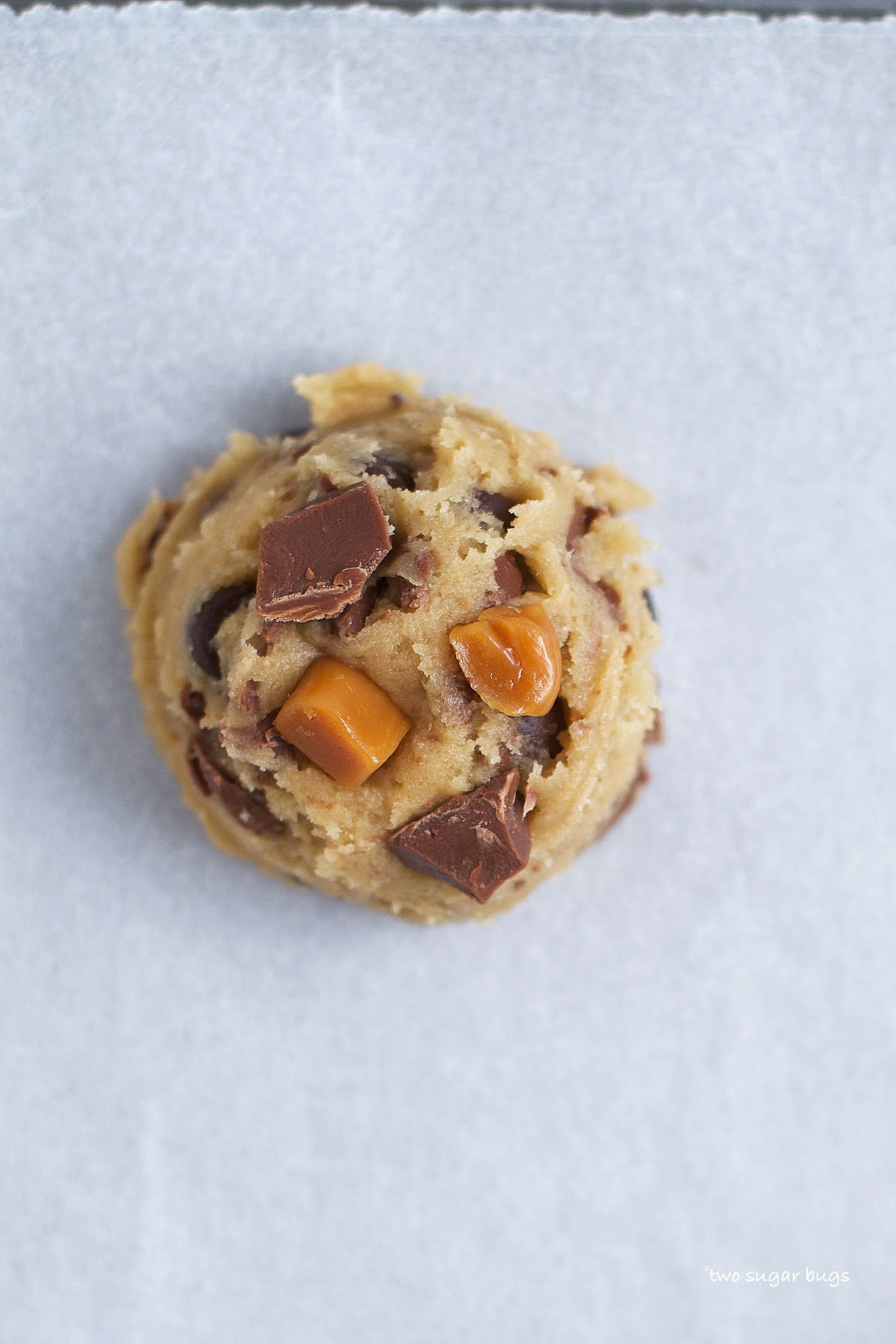 unbaked caramel chocolate chip cookie on parchment paper