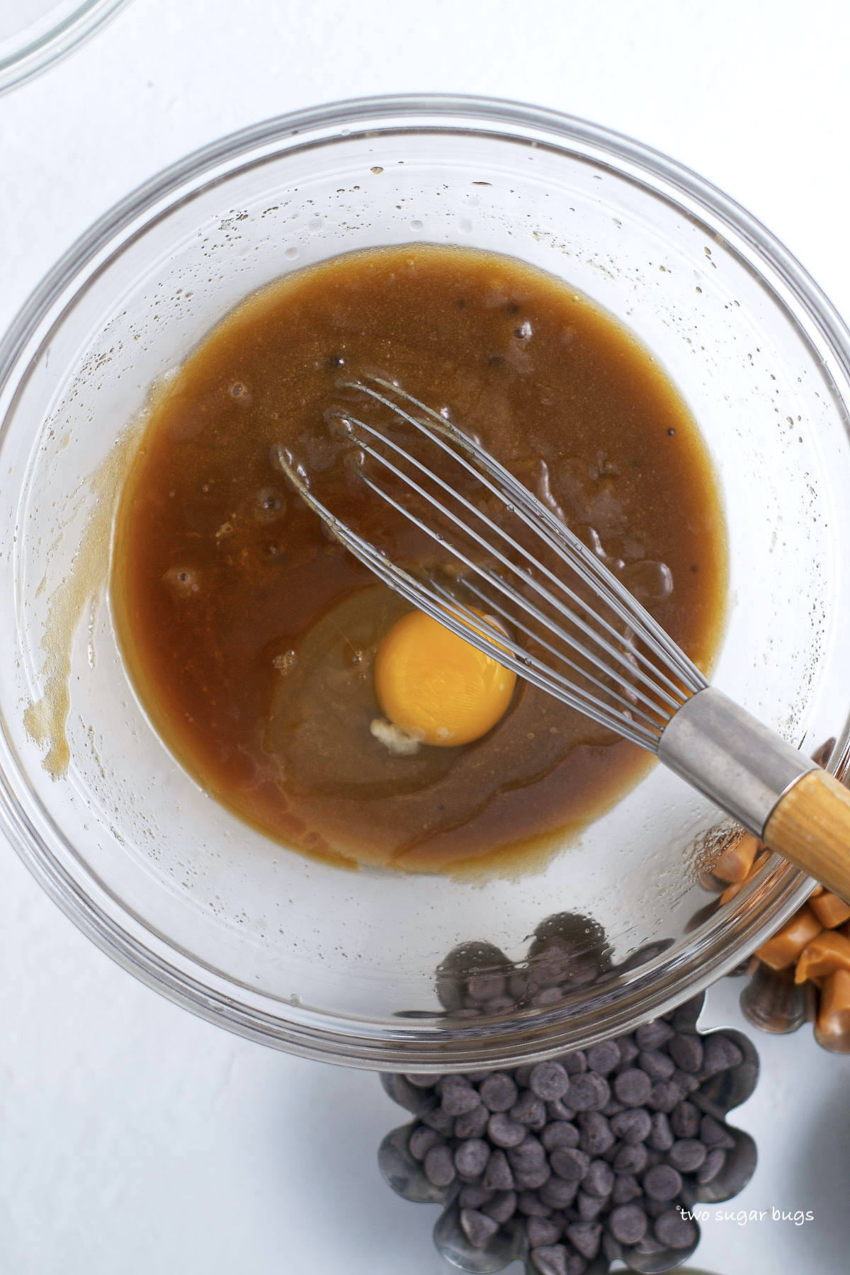 egg and vanilla added to butter and sugars in a bowl