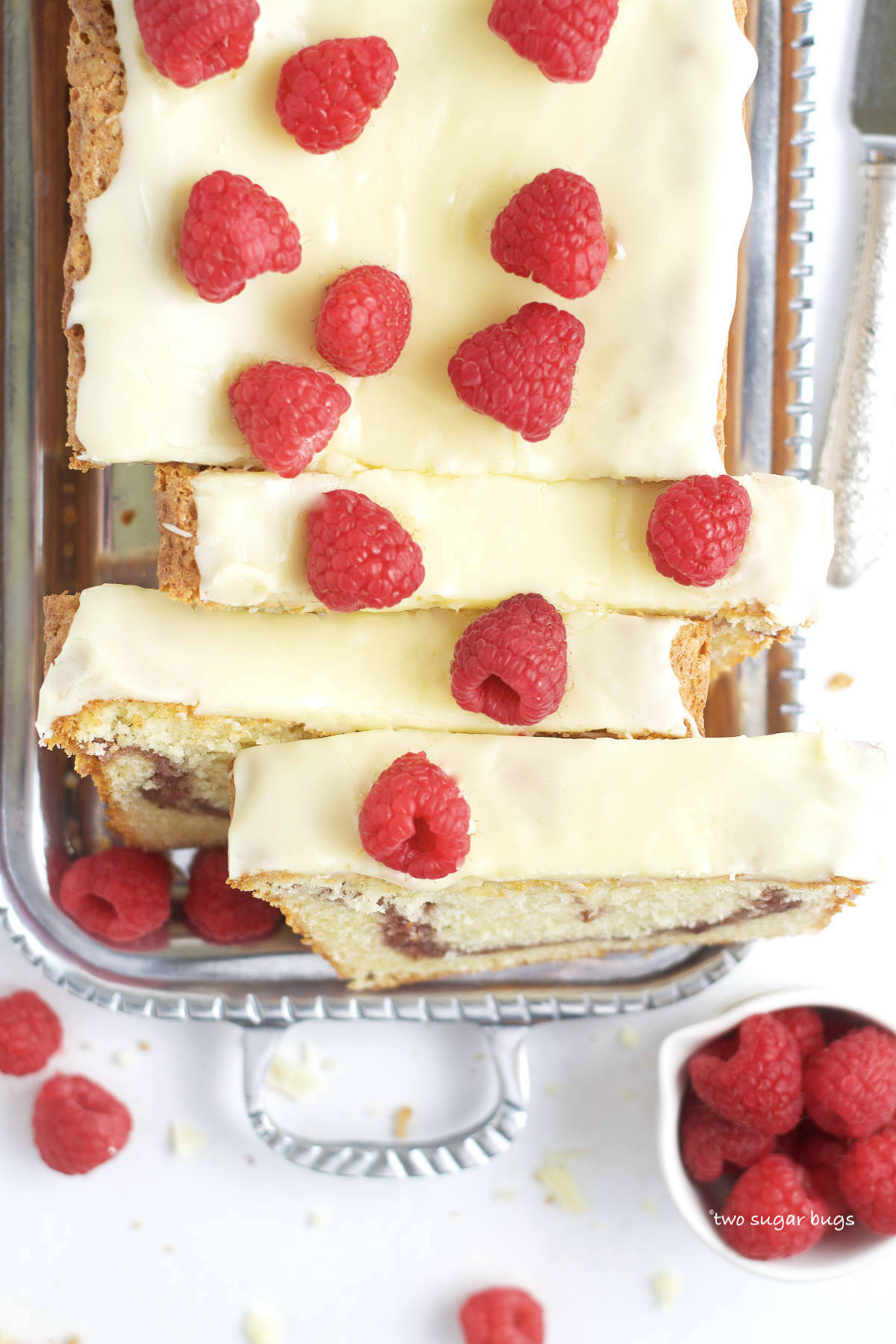 white chocolate ganache icing and fresh raspberries on top of cake