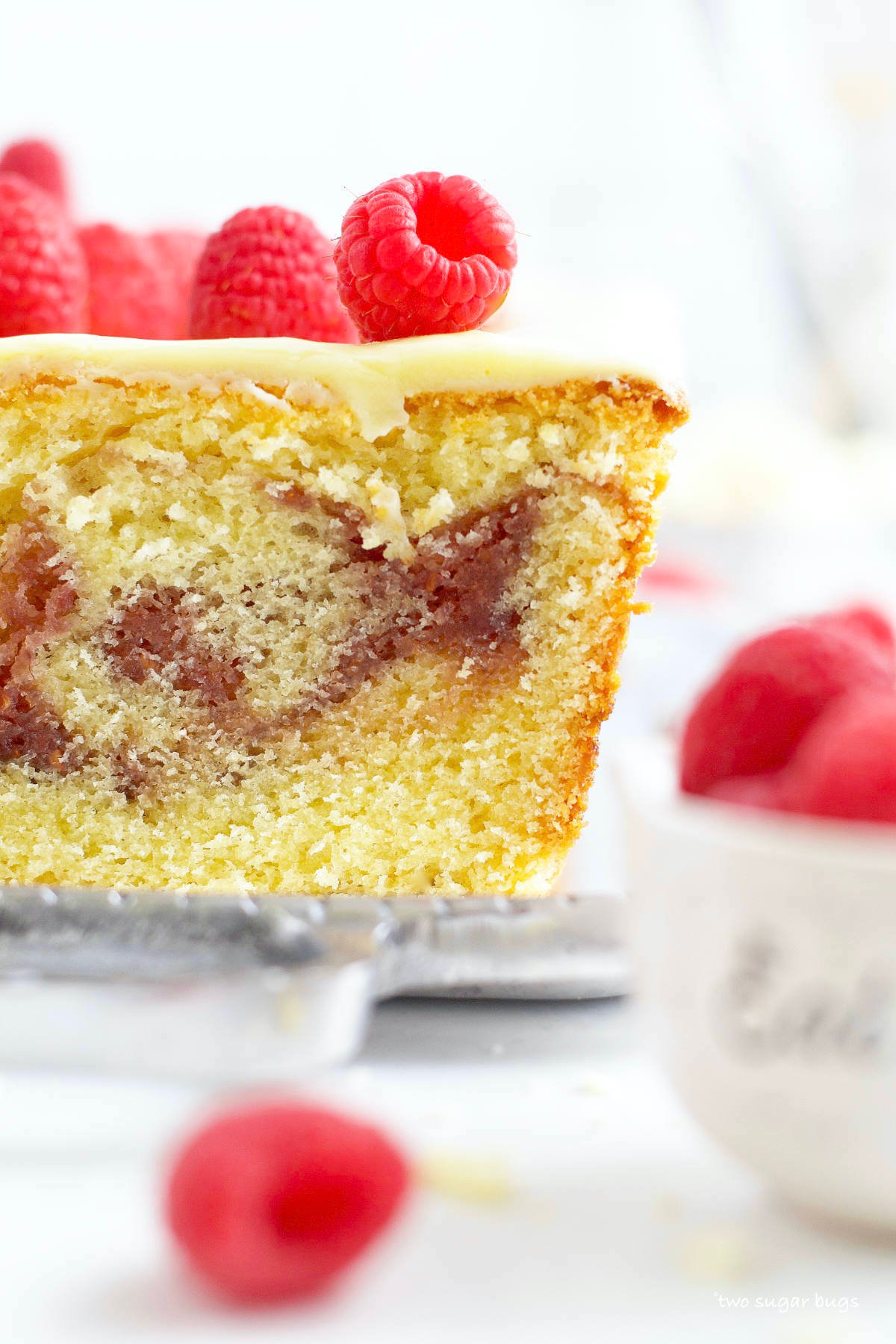 slice of raspberry white chocolate cake with raspberries on top