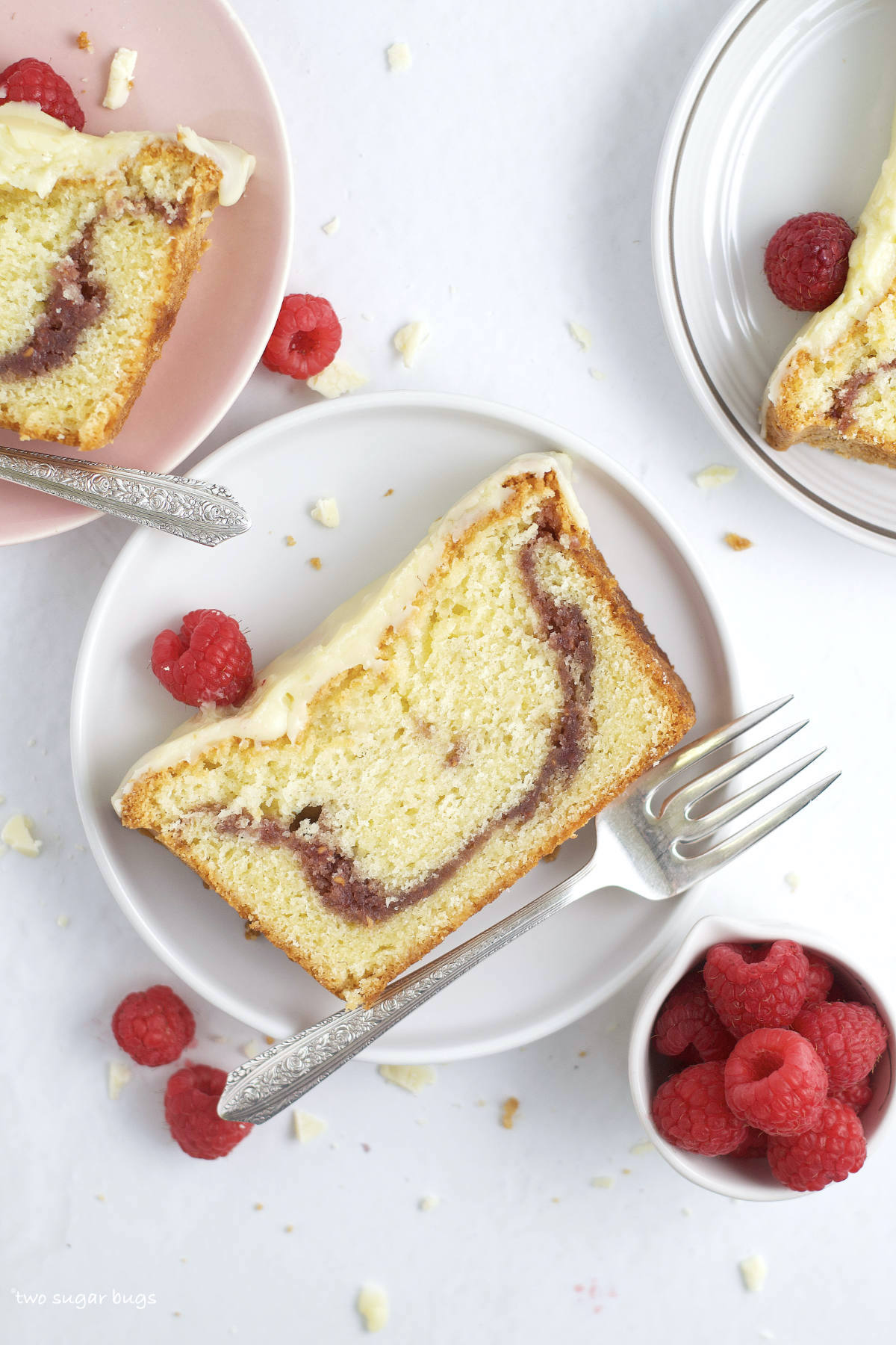 slices of raspberry white chocolate cake on plates with forks