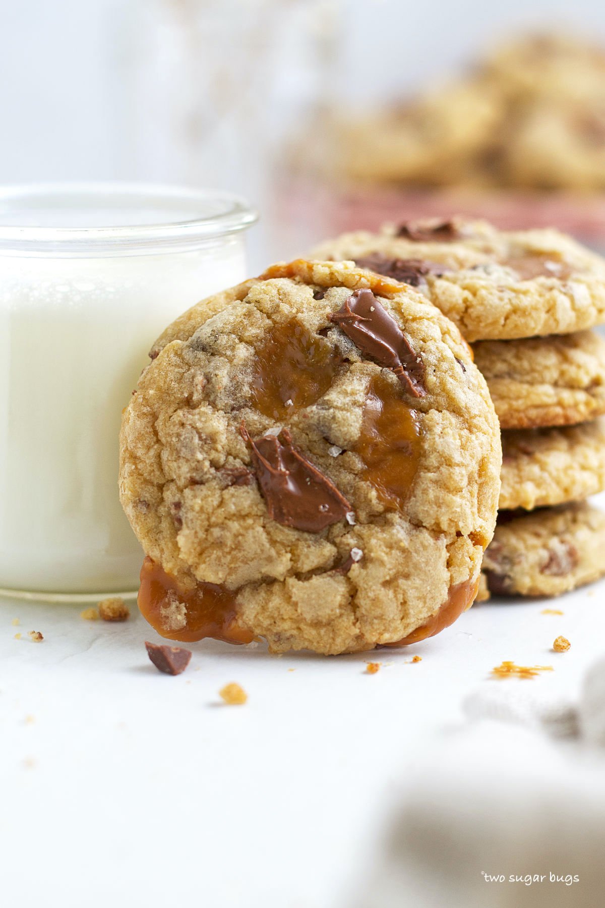 caramel chocolate chip cookie with a glass of milk