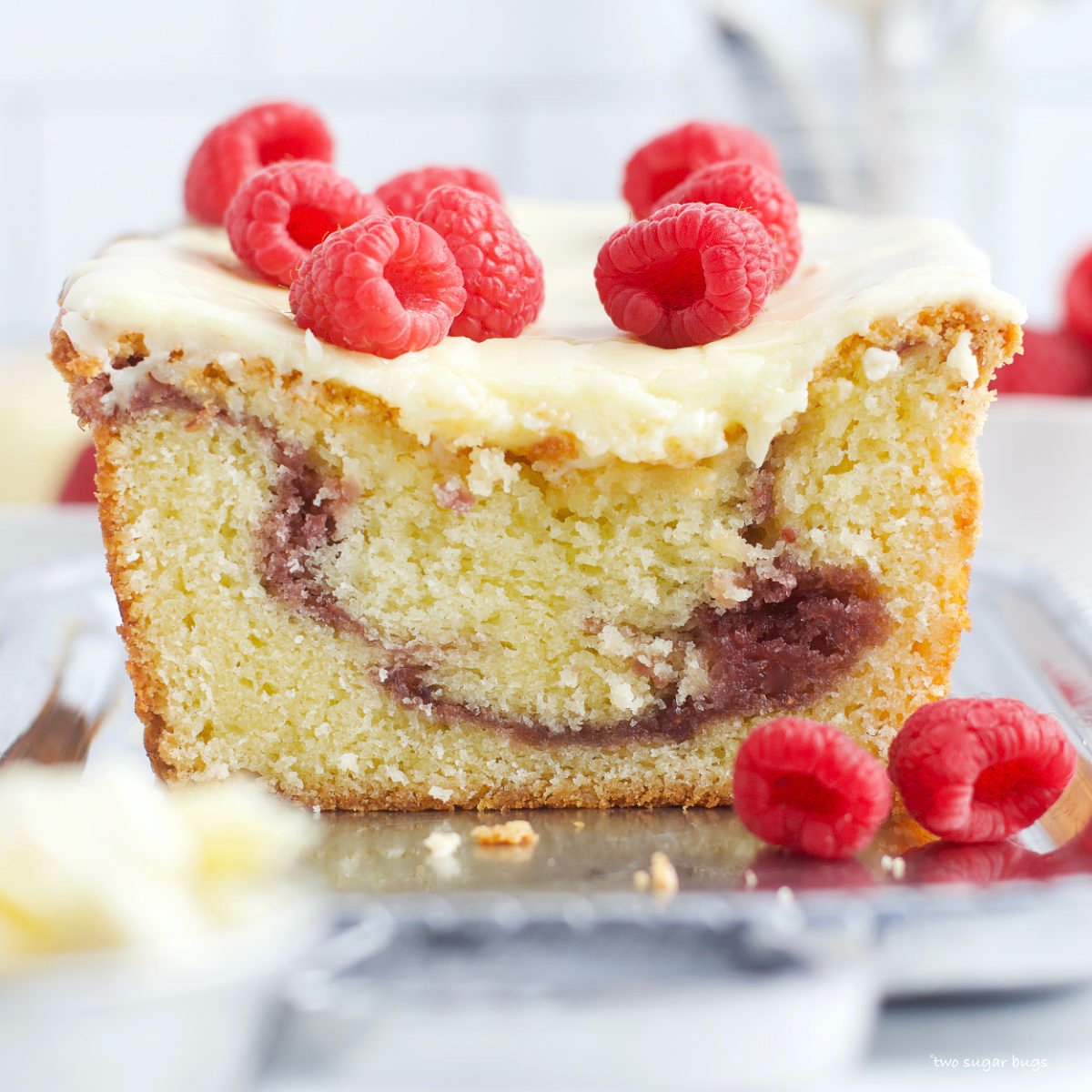 raspberry white chocolate loaf cake on a serving plate