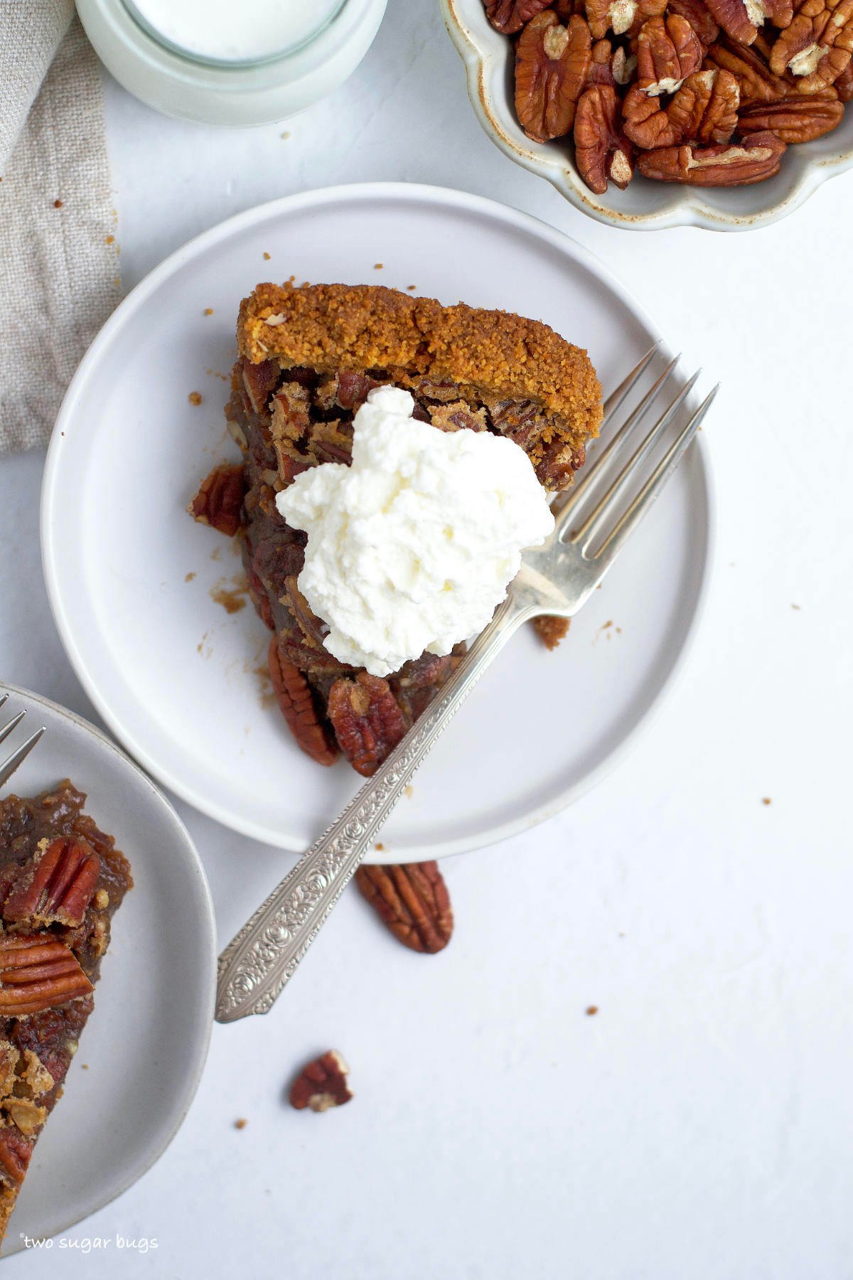 slice of pecan pie with graham crust and whipped cream on top