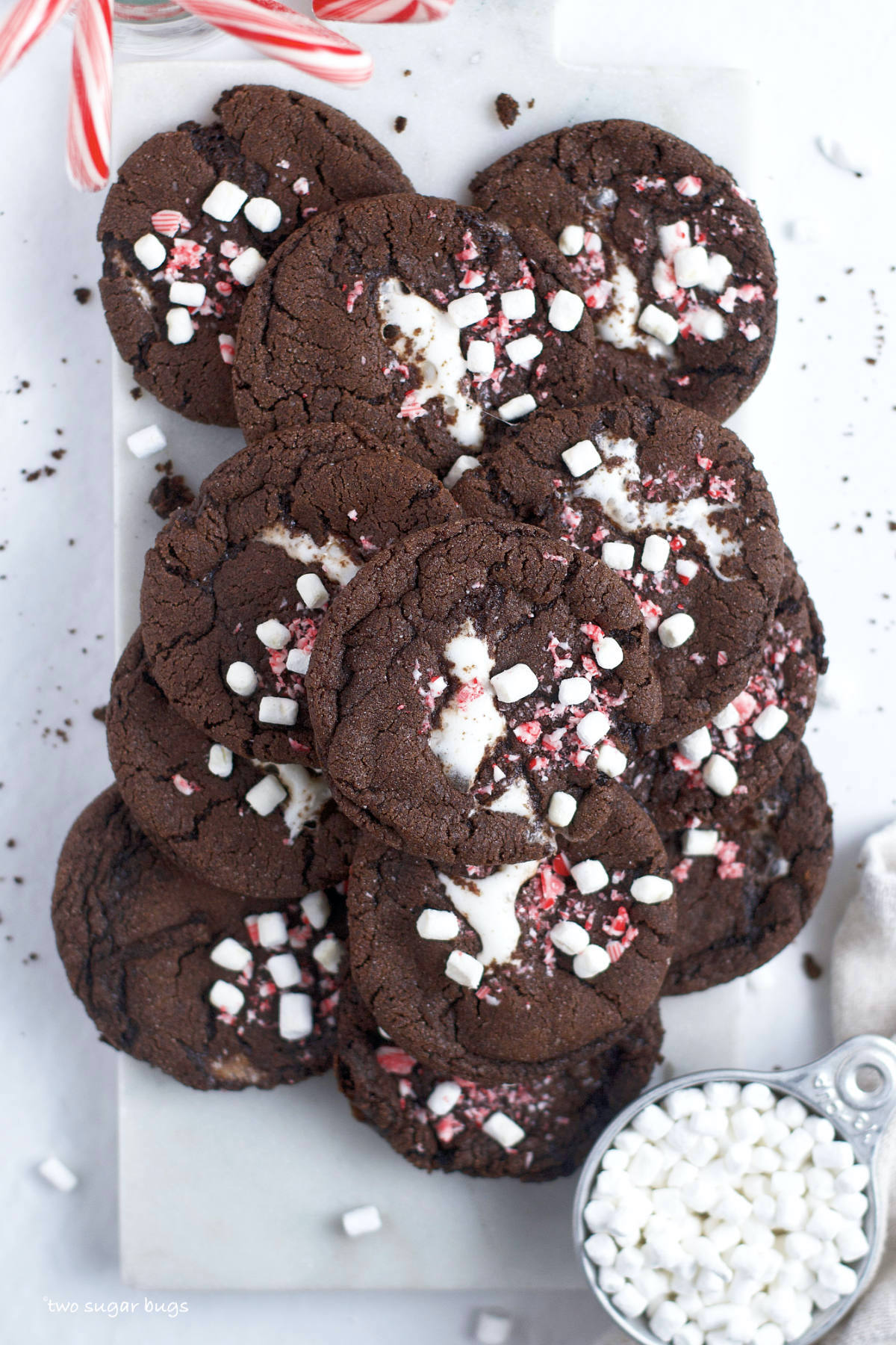 pile of peppermint hot cocoa cookies with a cup of mini marshmallows