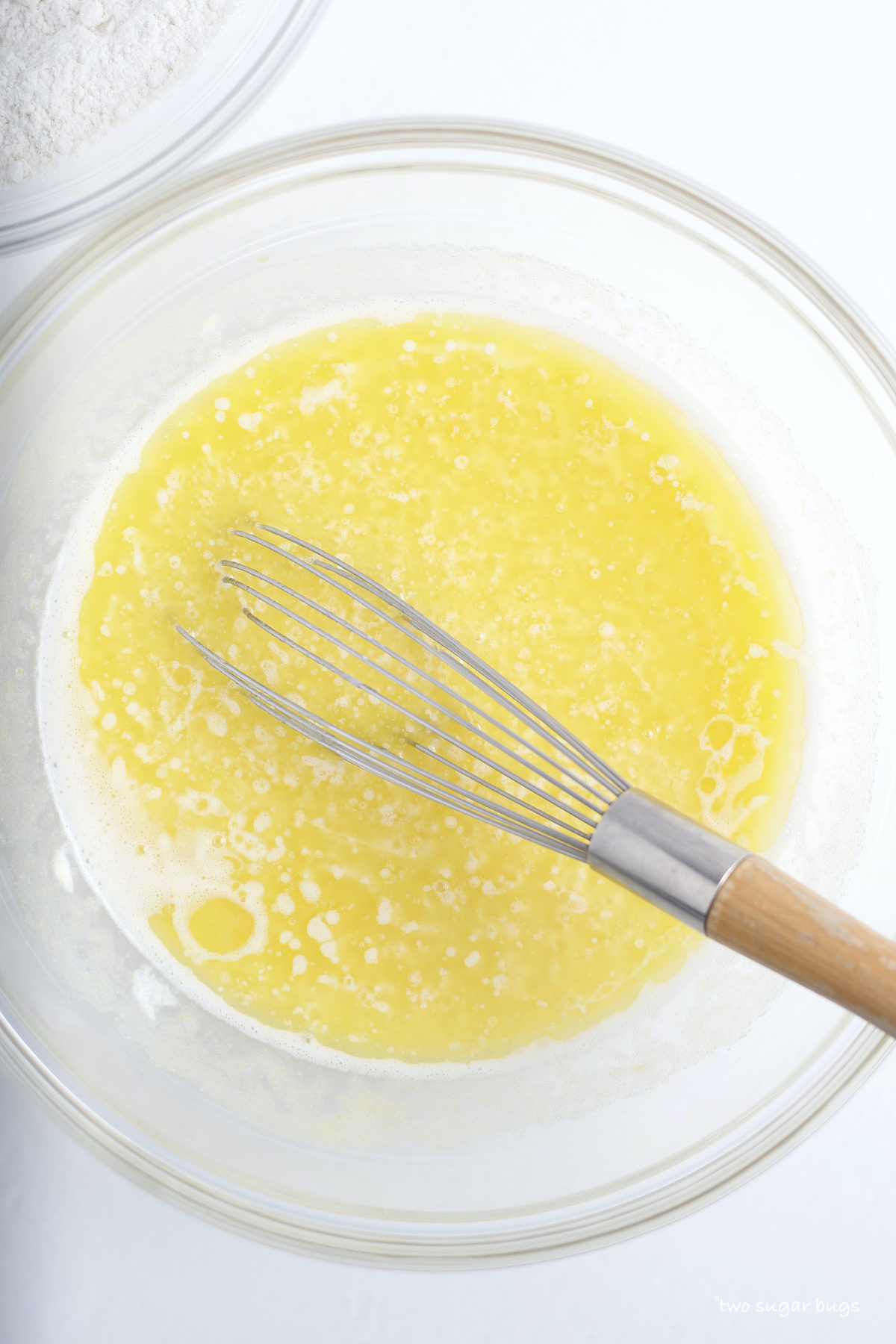 melted butter and milk in a mixing bowl with a whisk