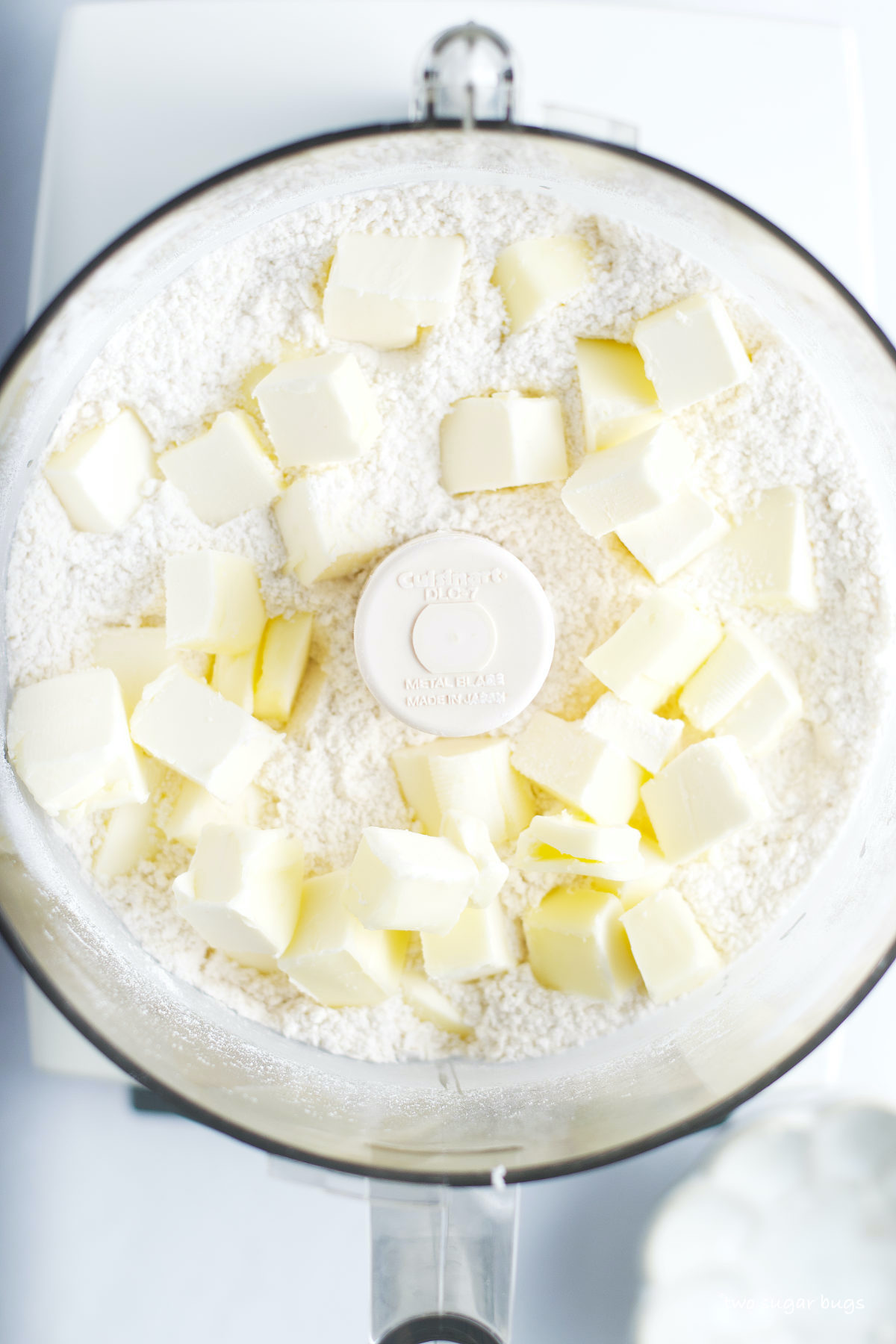 chunks of butter on top of flour in food processor