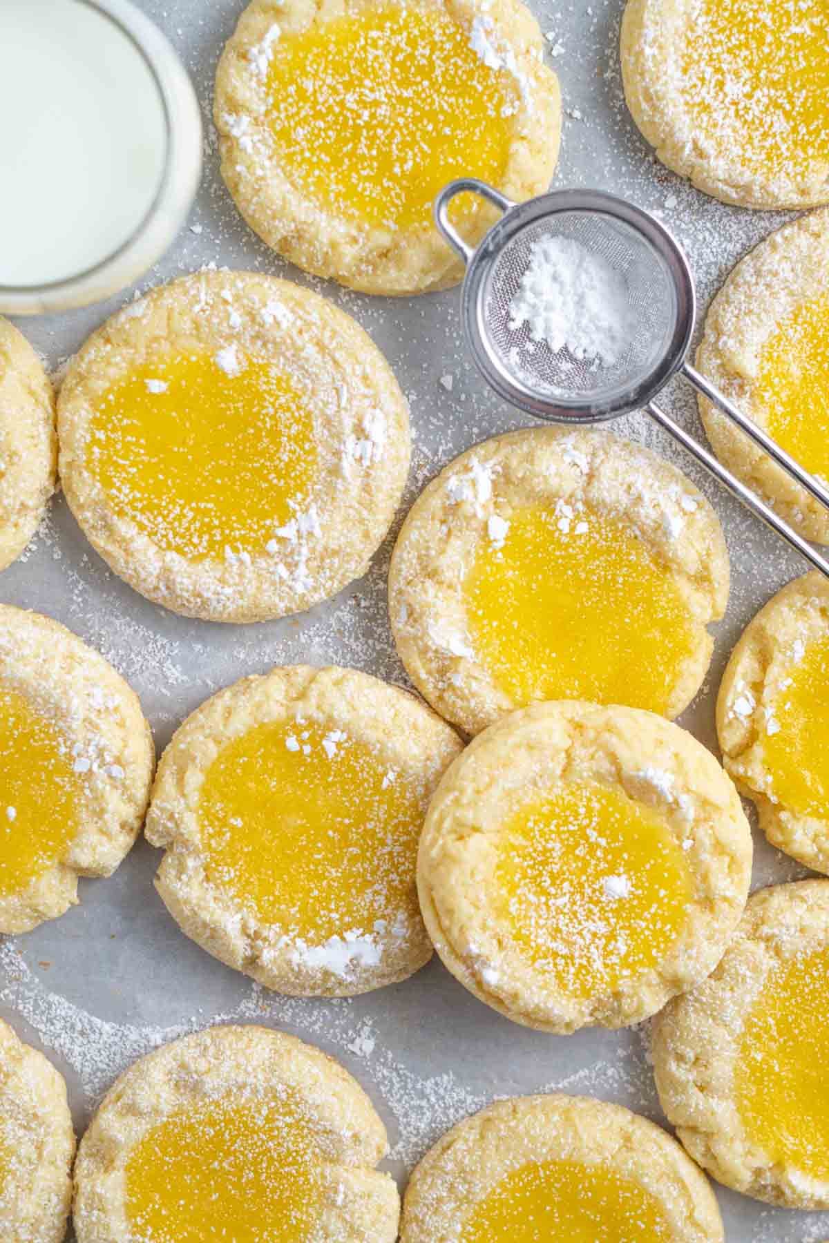 lemon bar cookies with confectioners' sugar and milk on parchment paper