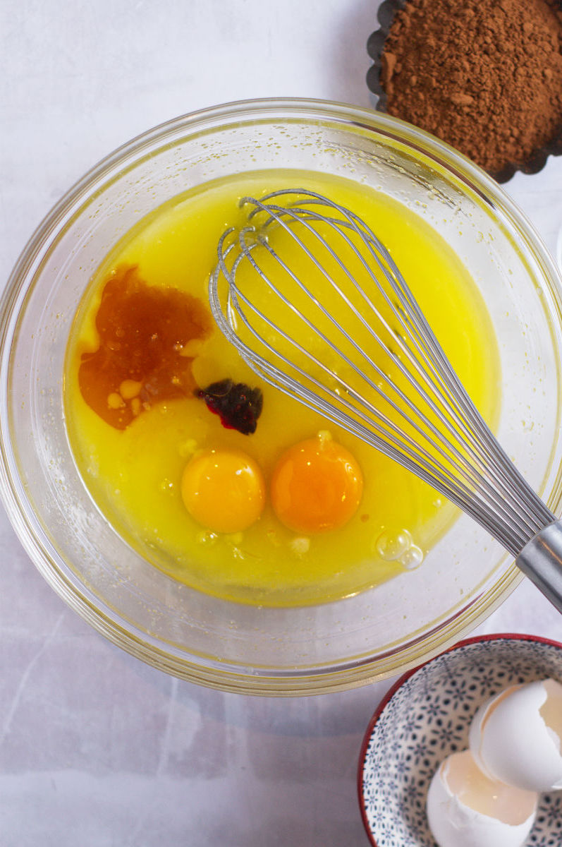 melted butter, sugar, eggs, vanilla and red gel coloring in a mixing bowl