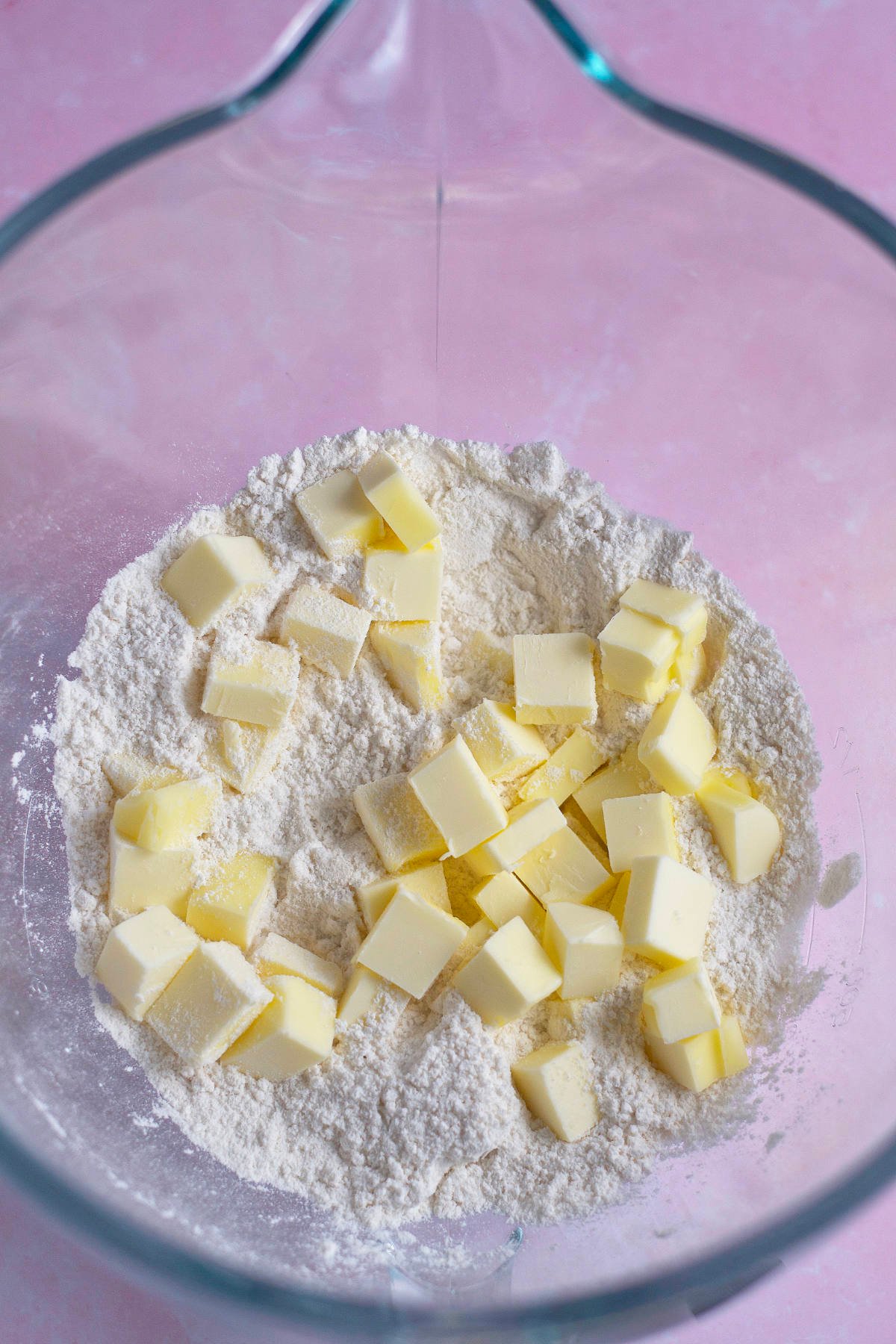 cubes of butter added to dry ingredients in a mixing bowl