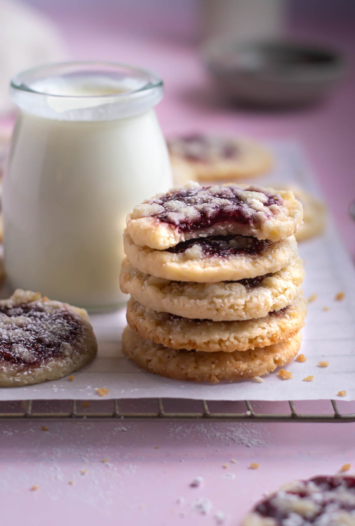 stack of raspberry crumble cookies with a glass of milk