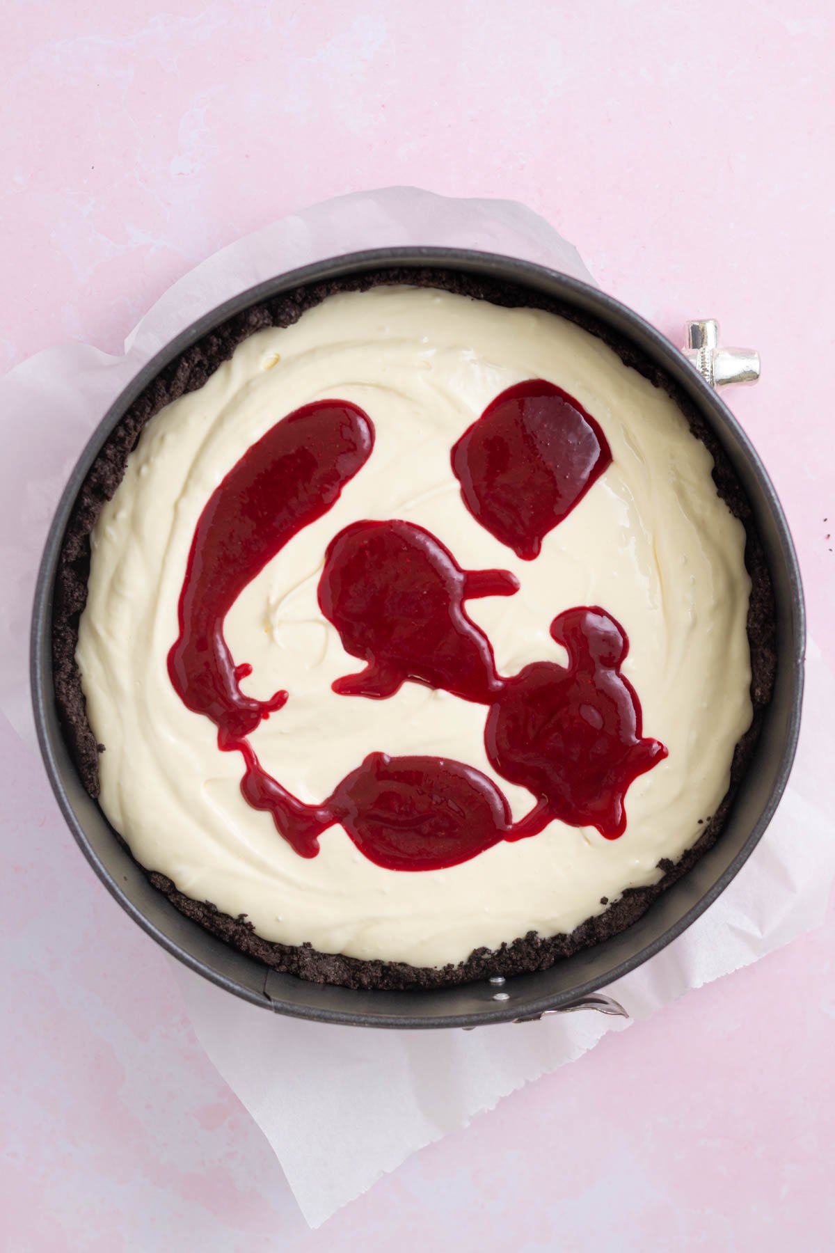 raspberry coulis over cheesecake batter