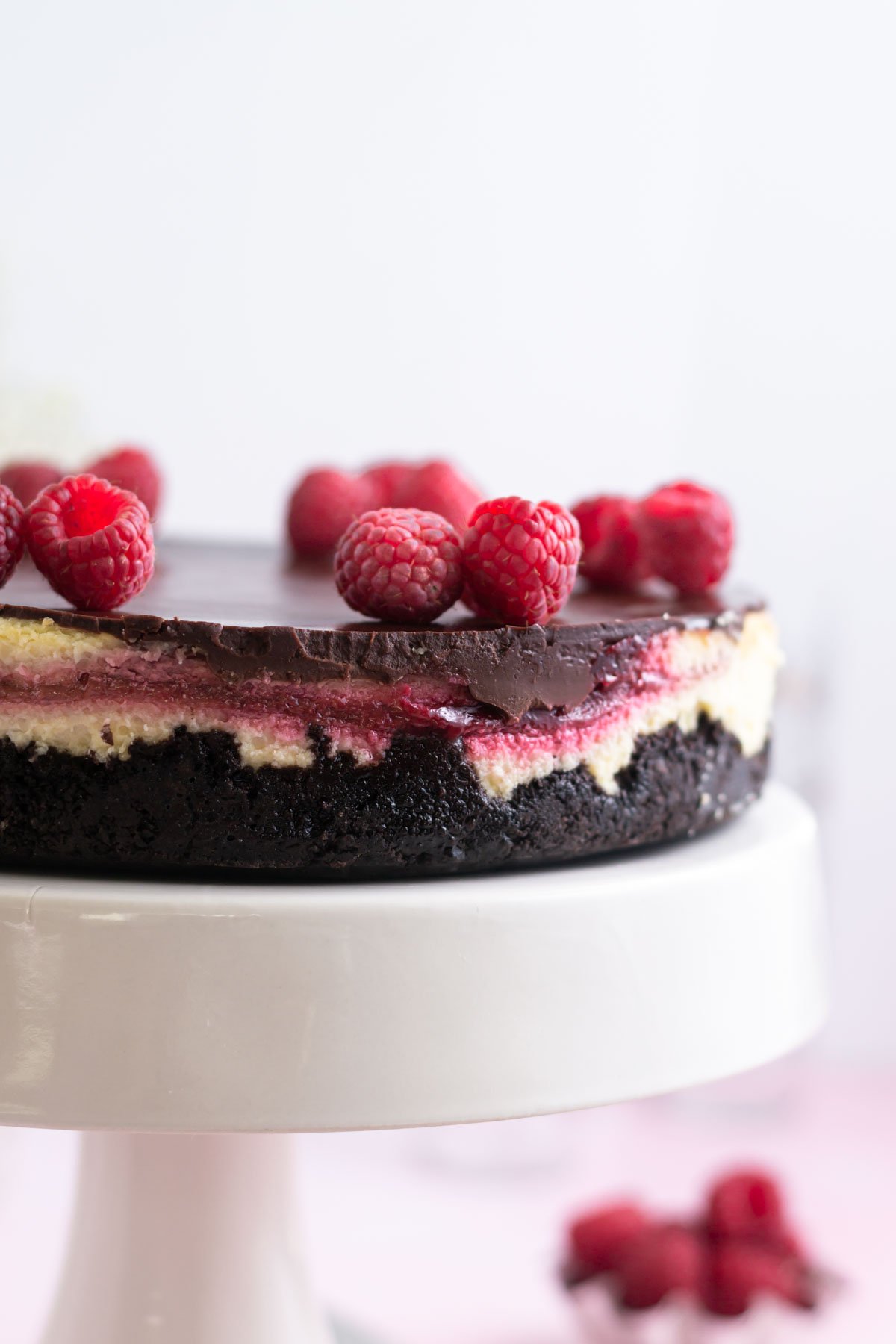cheesecake with fresh raspberries on a stand