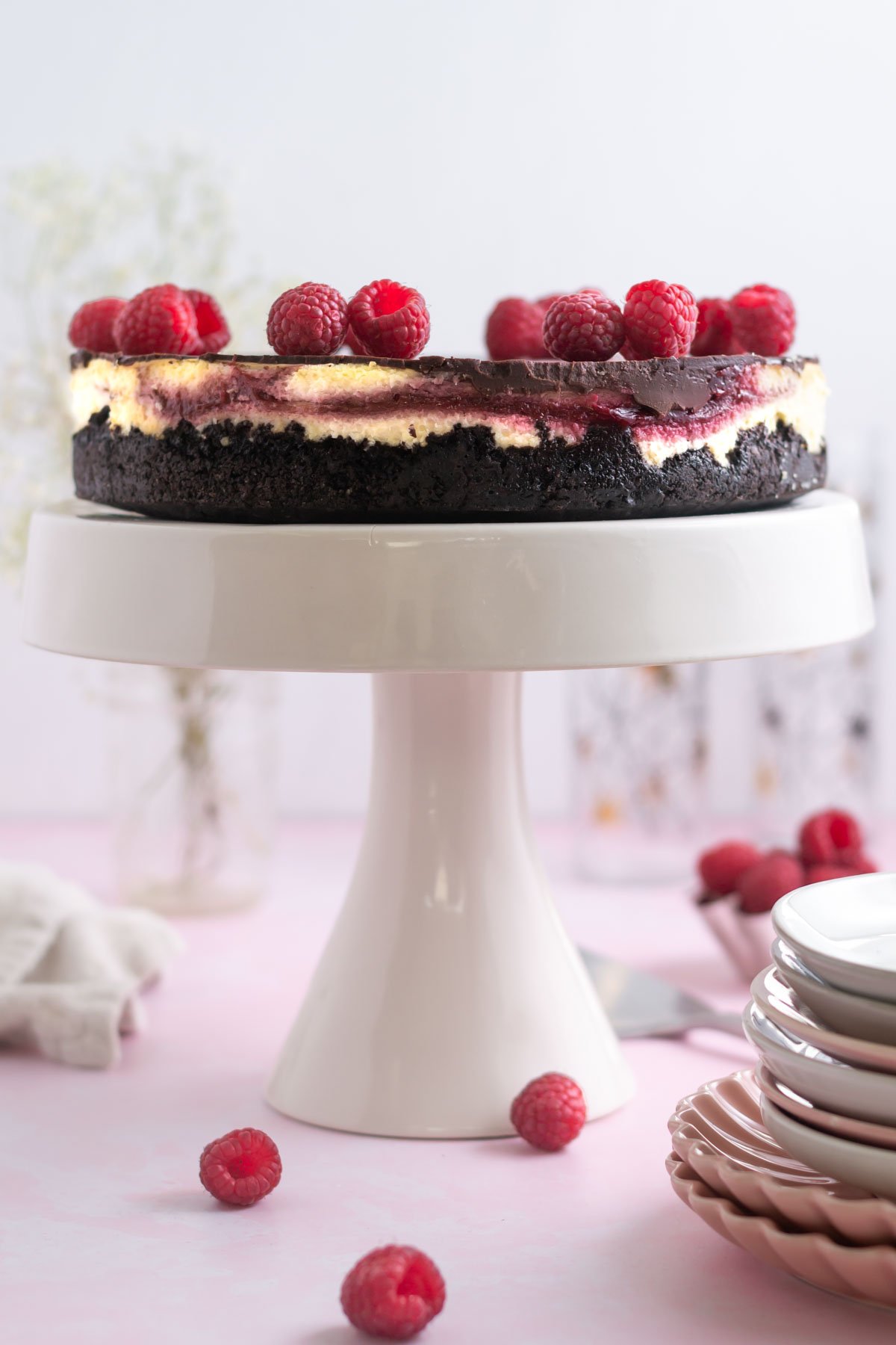 chocolate raspberry cheesecake on a cake stand